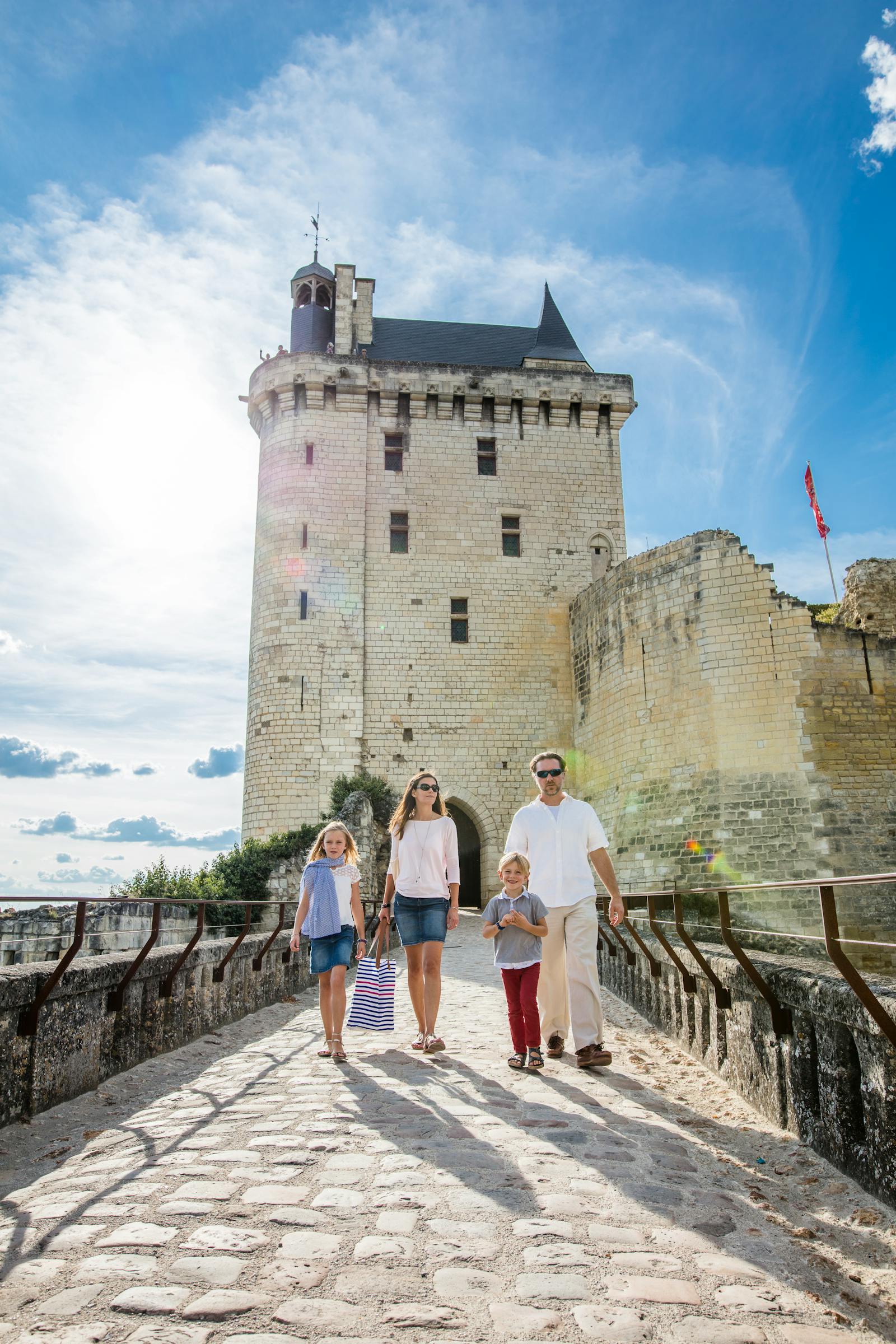 En familj som går framför den kungliga fästningen i Chinon